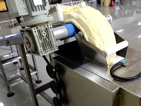 Incline conveyor conveys dough to entry and is controlled by sensor