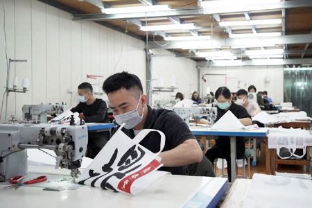 Linea di produzione di borse isolanti e borse in tela cucite a mano personalizzate.
